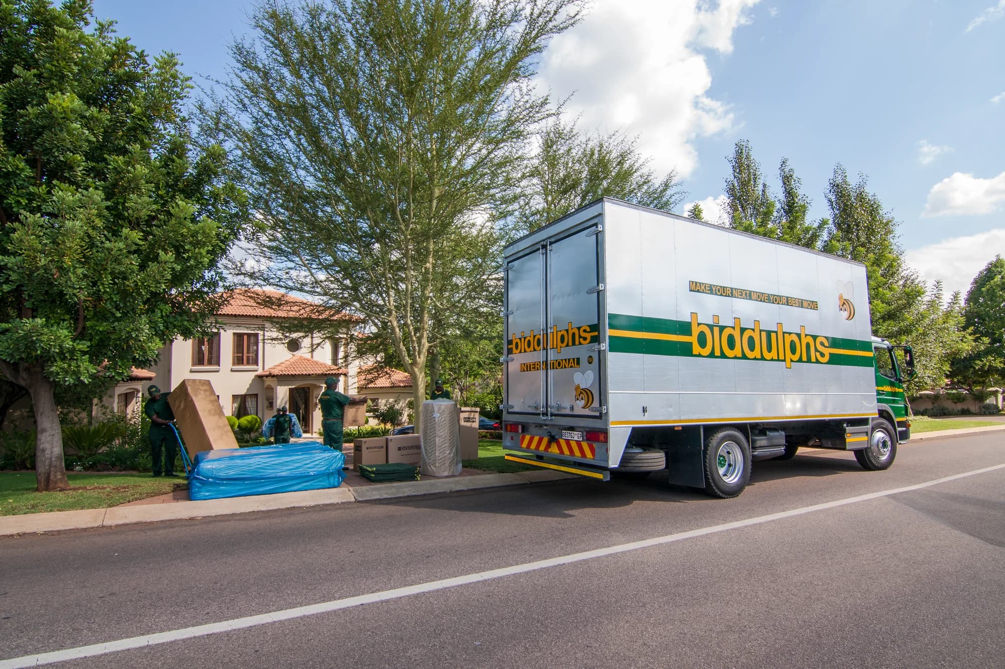 Wrapped furniture and cartons beside a Biddulphs removal truck
