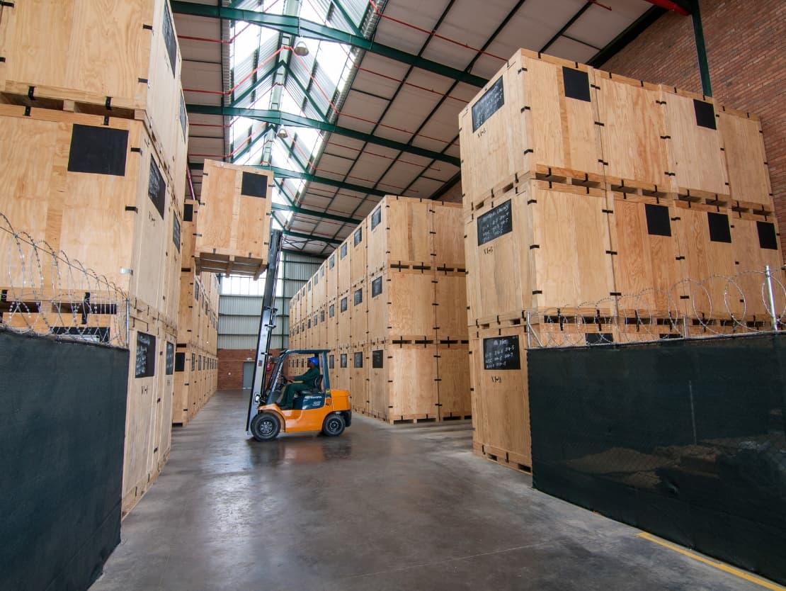 Wooden storage crates and a forklift in a Biddulphs warehouse